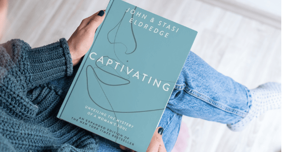 Woman holding the book Captivating by John & Stasi Eldredge – Christian book recommendation for women