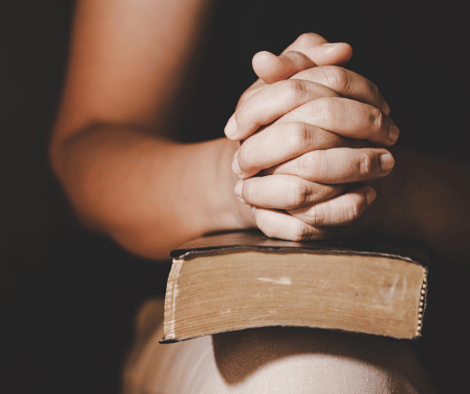 Someone saying a prayer of thankfulness with their bible